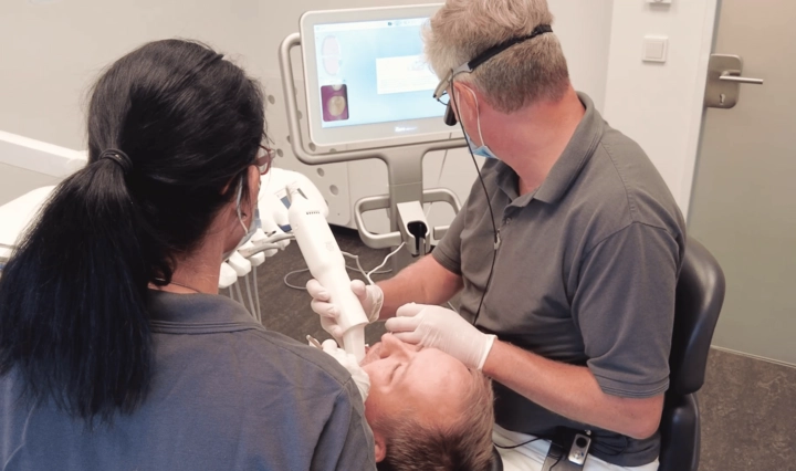Dr. Herzberg scannt mit einem Intraoralscanner das Gebiss des Patienten
