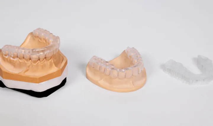 Okklusionsschienen aus klarem Kunststoff, aufgestellt auf Zahnmodellen aus Gips, auf weißem Hintergrund